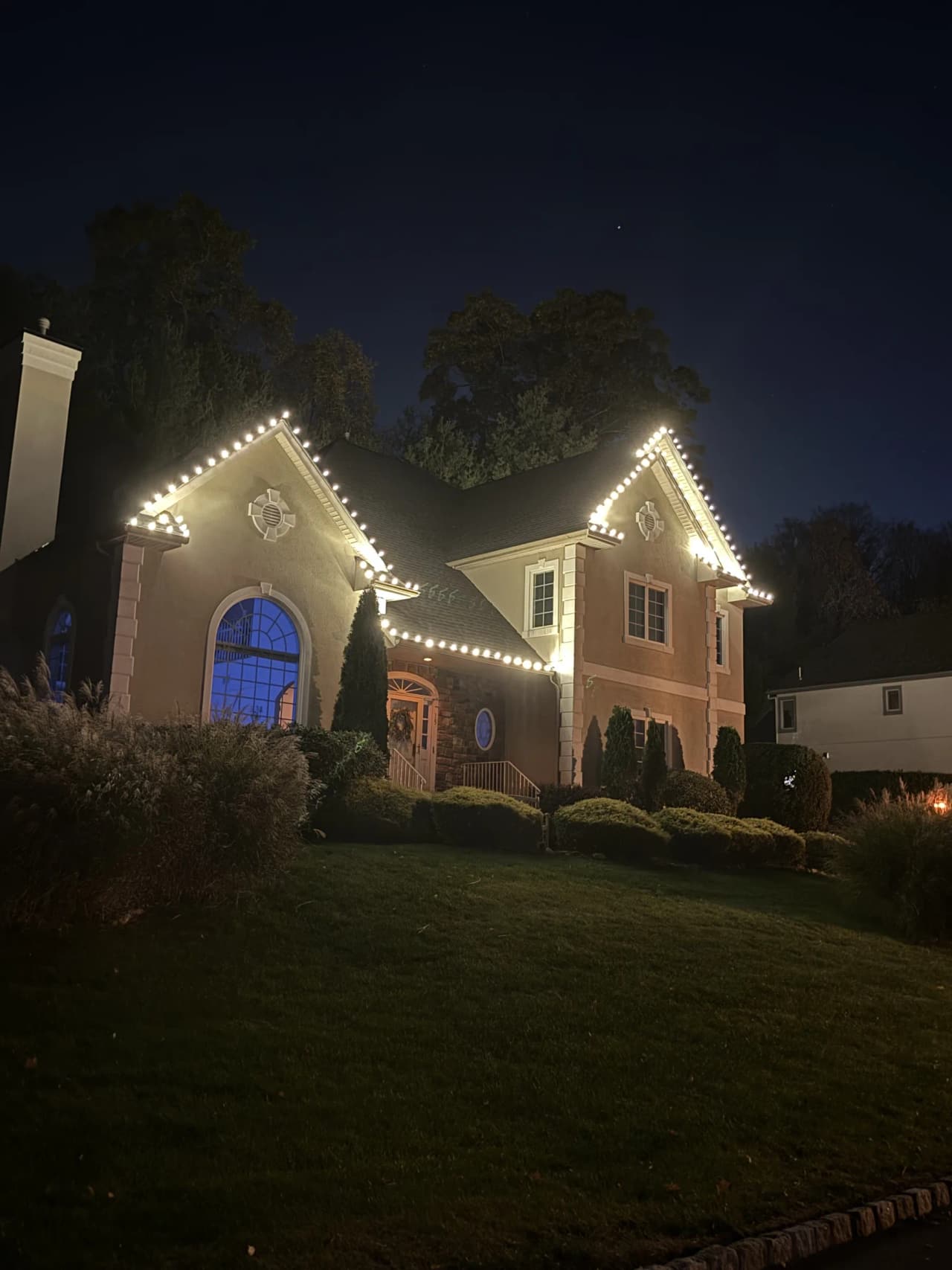 Brick home outlined with warm white Christmas lights
